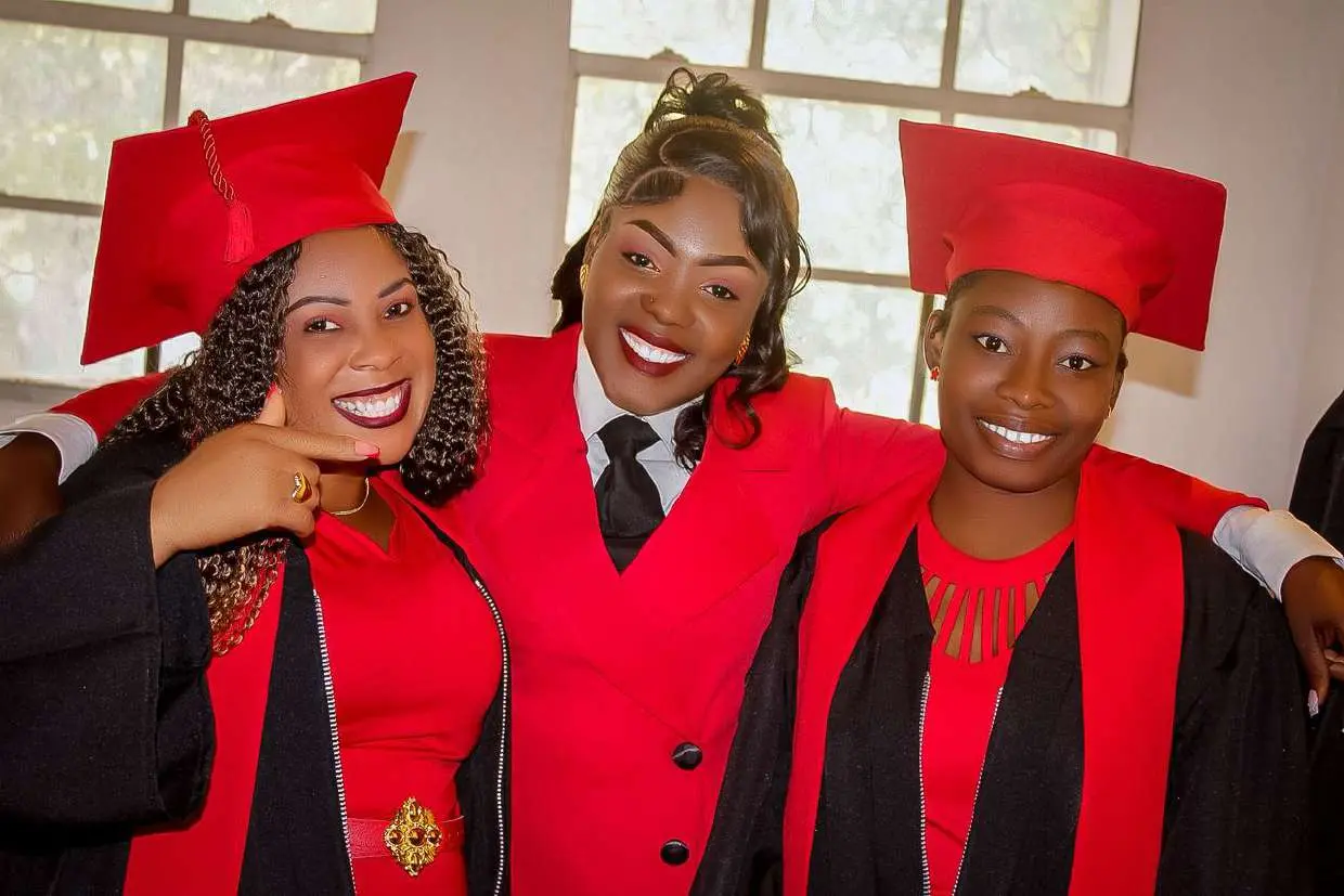Deux étudiantes en tenue de graduation aux côtés de la Directrice de MA Agency
